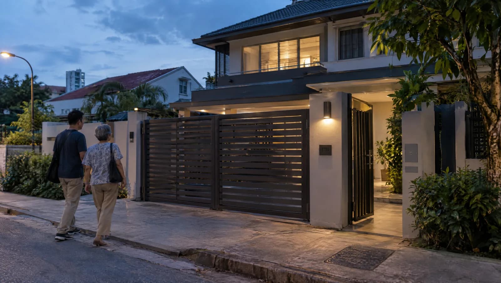 Residents returning to a home with a closed vehicle gate and a separate pedestrian entrance.