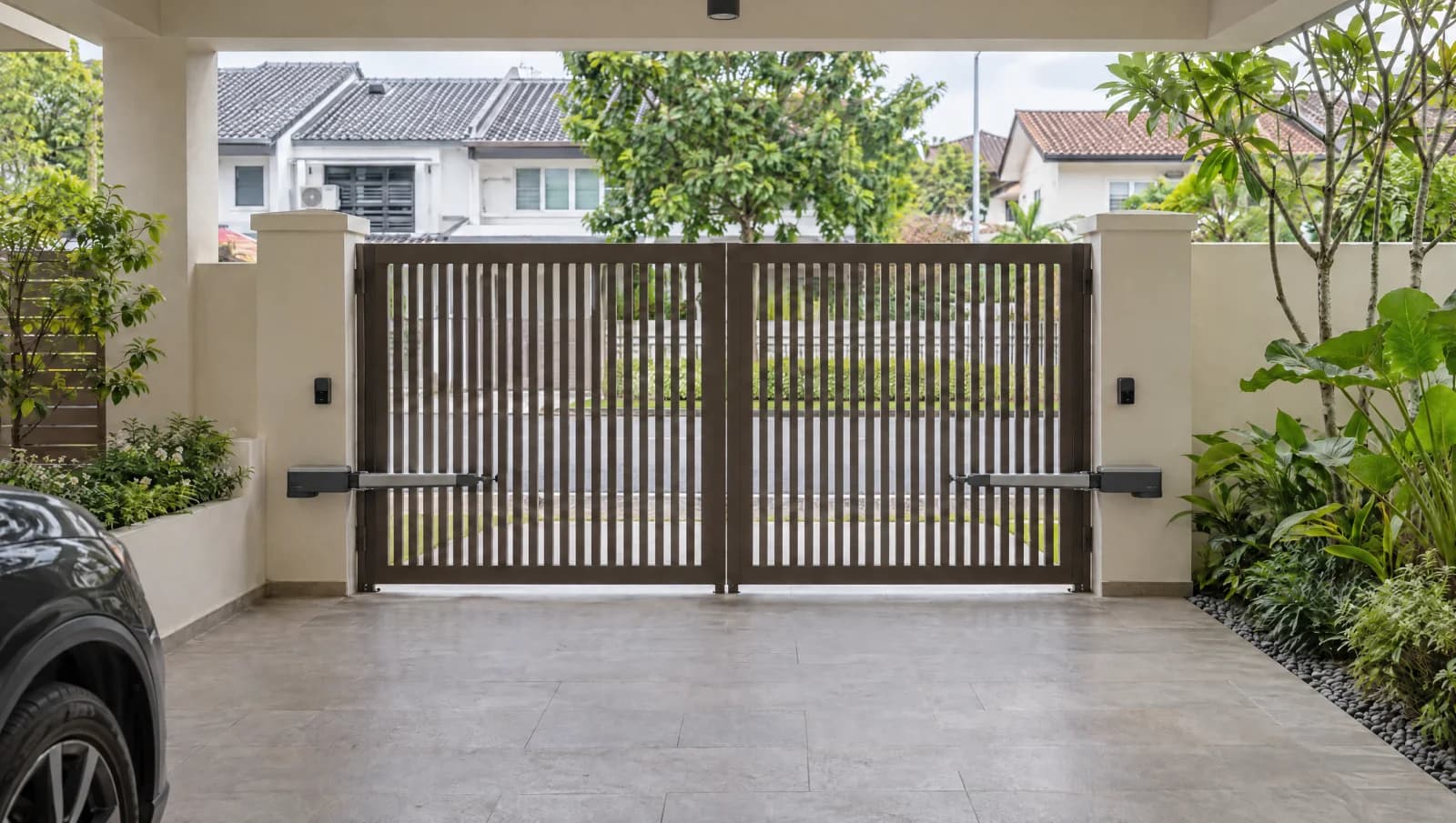 Closed two-leaf driveway gate with generic actuators at a Singapore landed home.