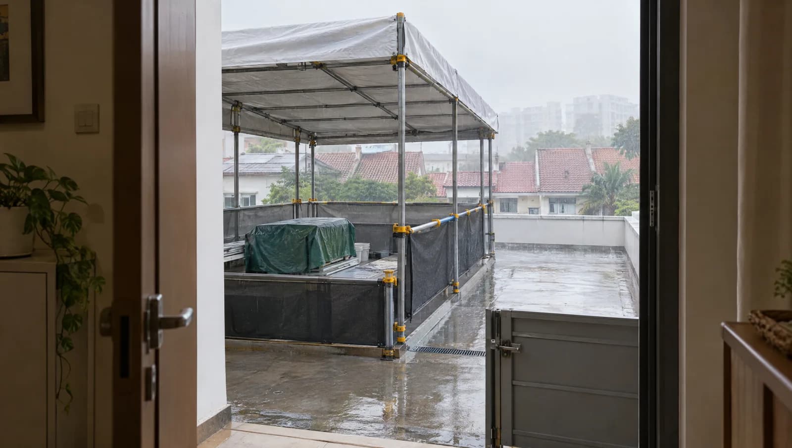 Sheltered view of a temporarily protected roof work area during a shower.
