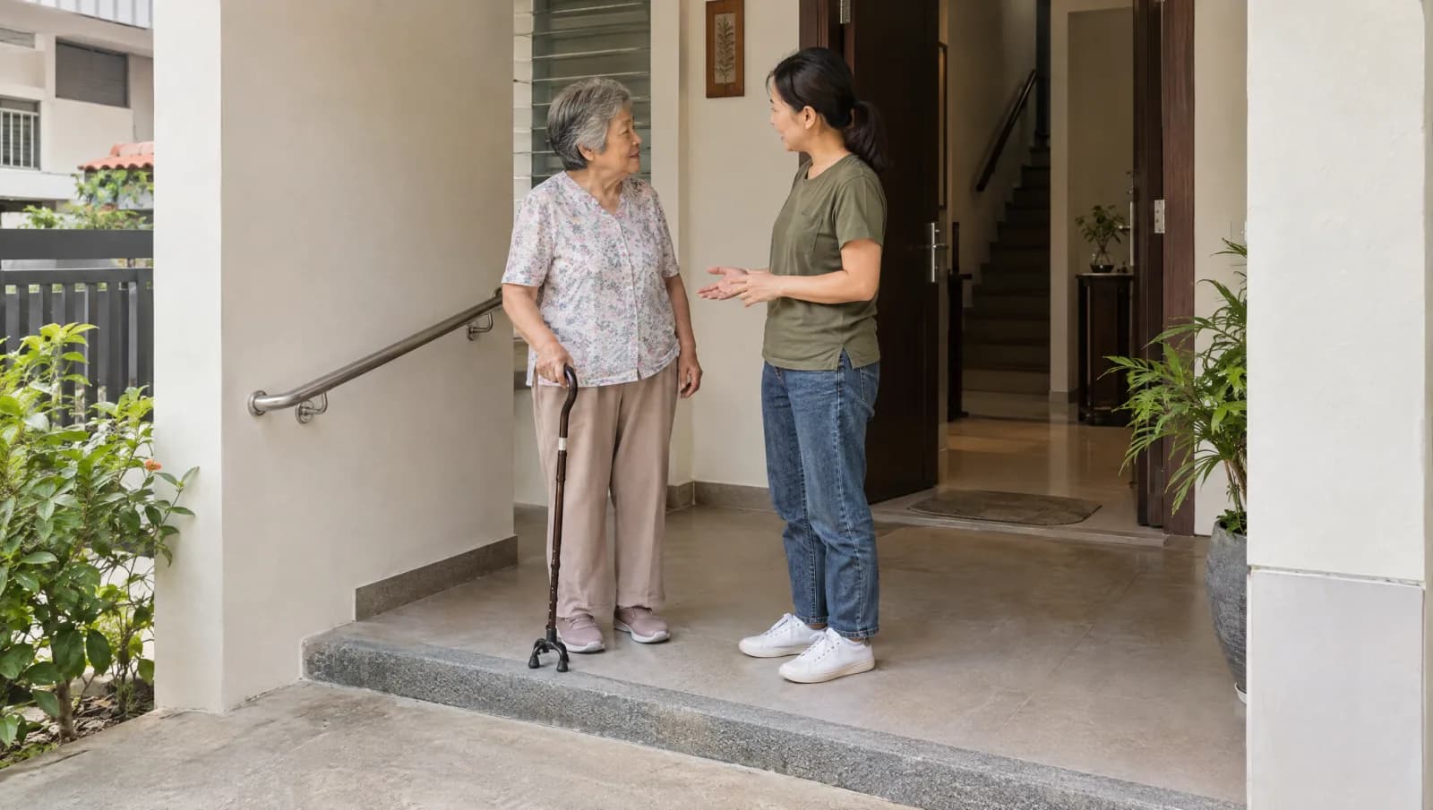 Older resident and family member discussing an entrance handrail at a private home.